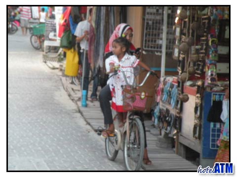 Local mother with kid riding a bicycle on Phi Phi